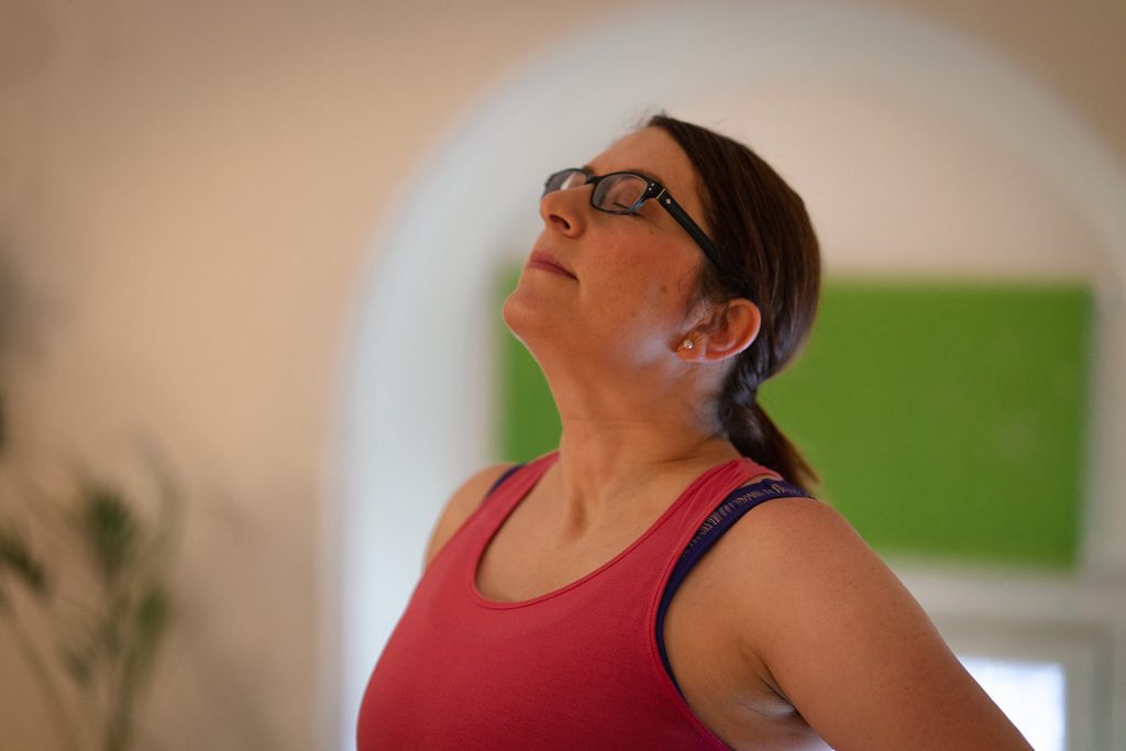 Lady looking to the ceiling, breathing deeply at a yoga session. 